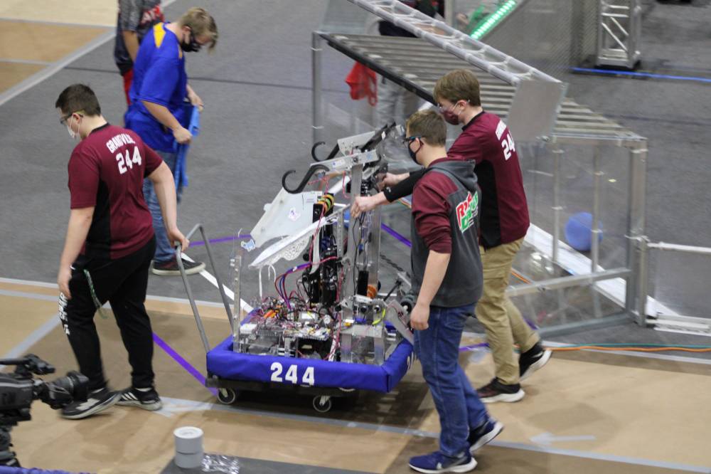 A team takes their robot off the field after a match